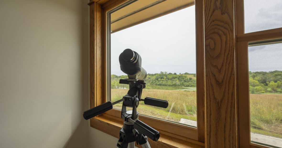 Binoculars on a tripod looking out the windows of the CERA residence