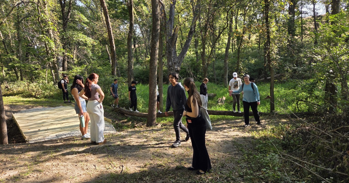 A group of ten people standing in a wooded forest