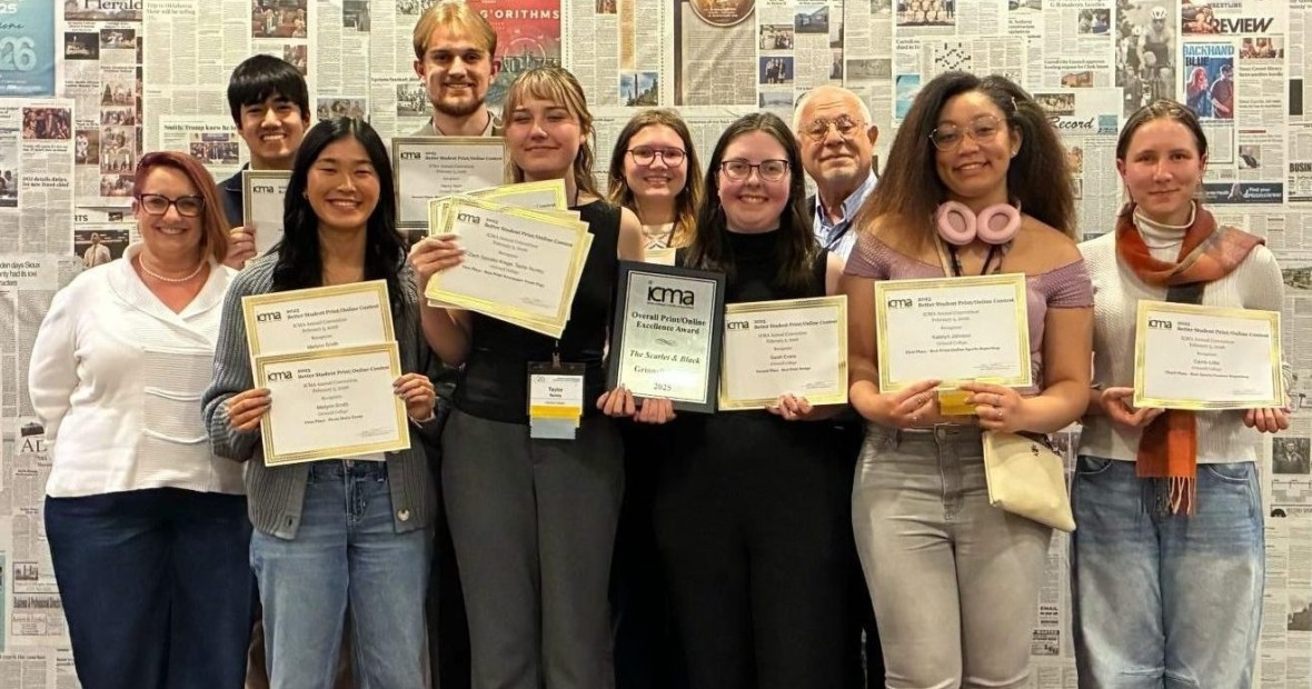 Ten people smiling and holding gold-edged paper certificates