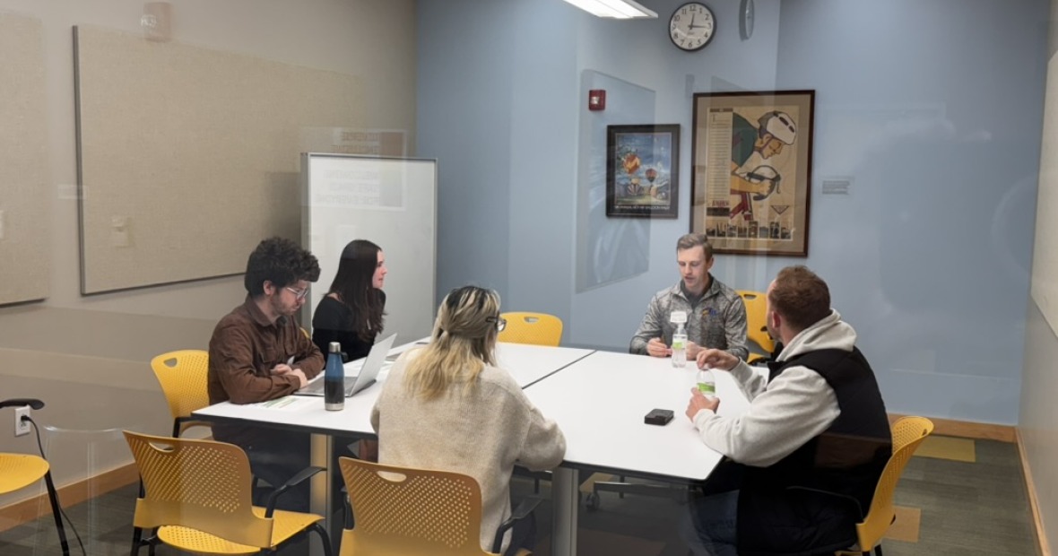 5 people sitting around a table discussing