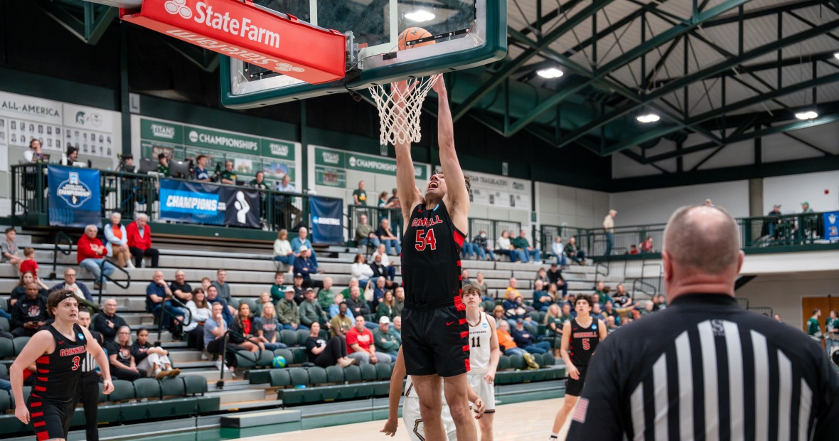 Grinnell basketball player in black hangs on the rim