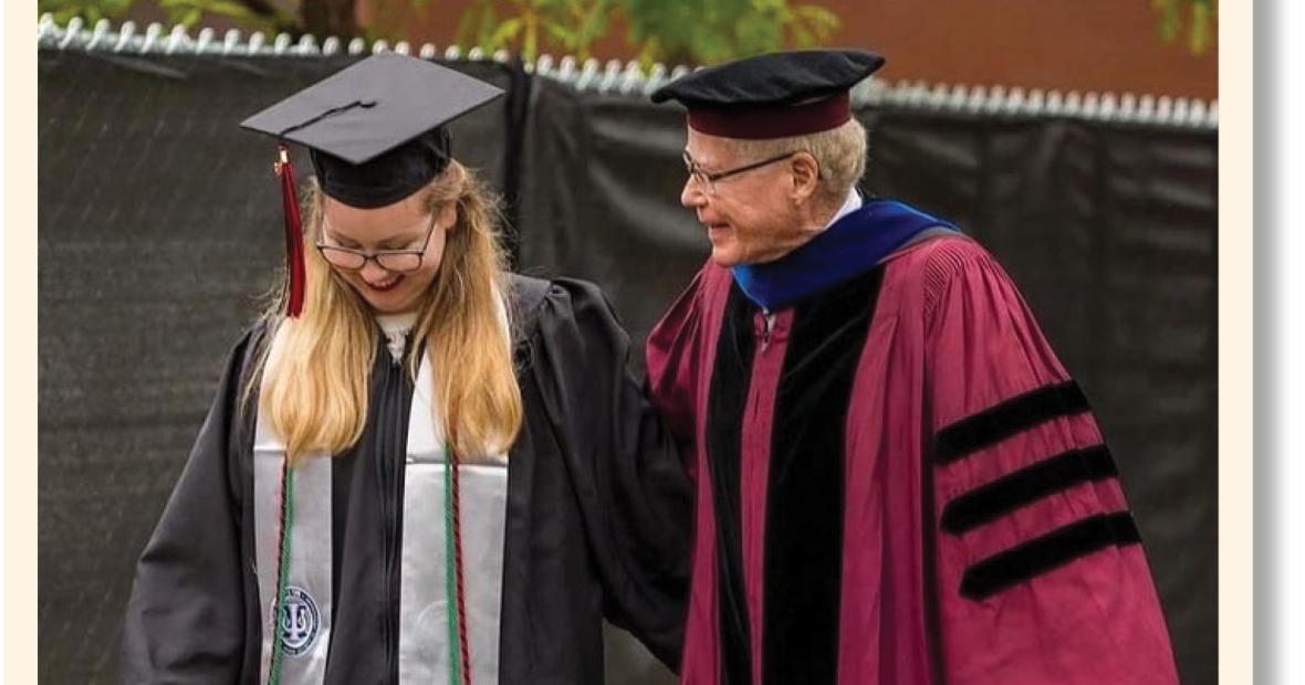 George Drake and his granddaugter Hannah in academic regalia walking arm in arm