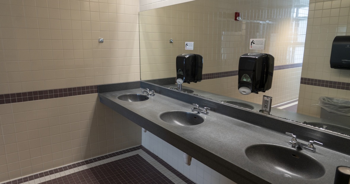 A bathroom showing stalls and two sinks.