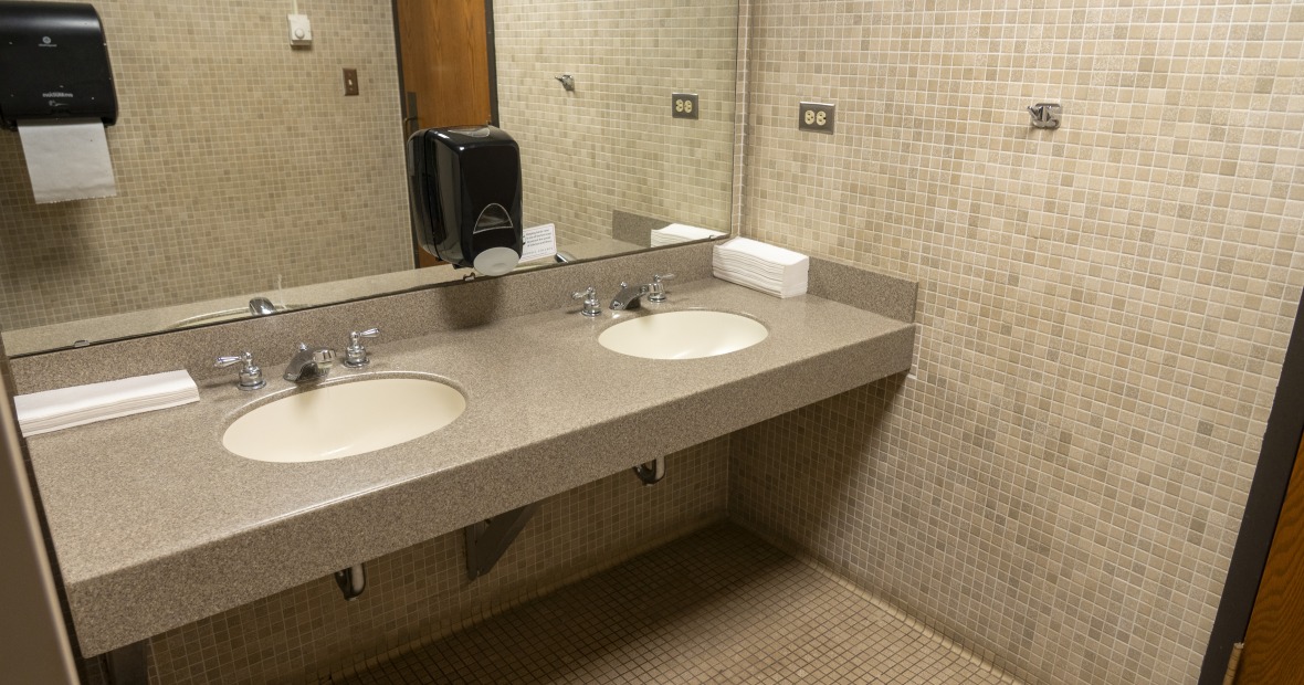 A bathroom showing stalls and two sinks.