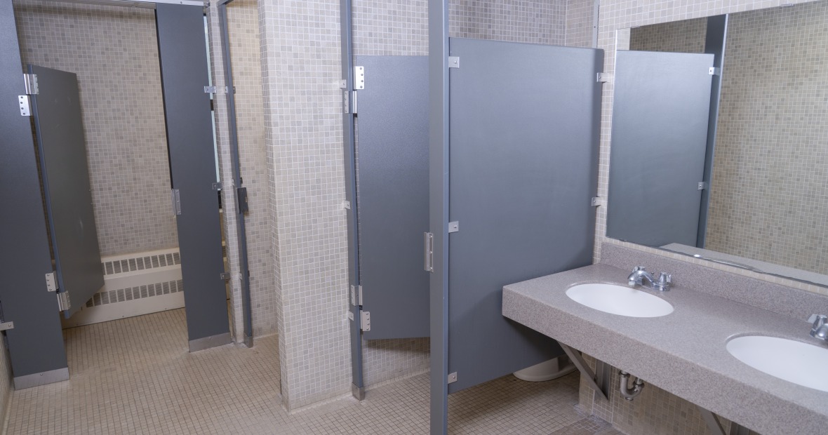 A bathroom showing toilet and shower stalls and two sinks.