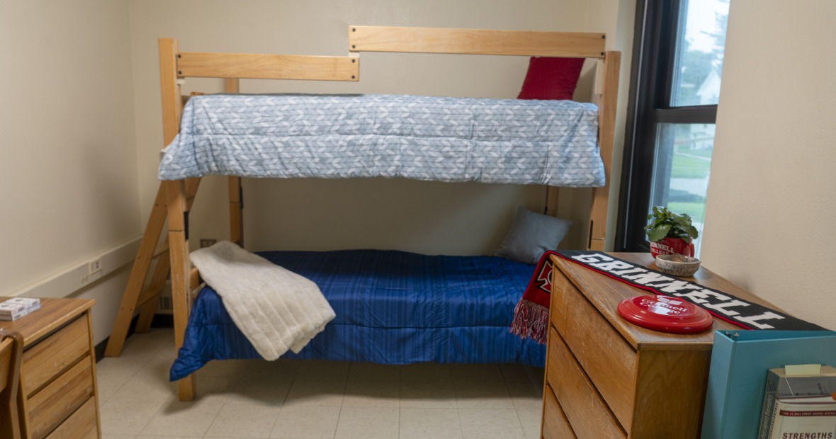 A double bedroom with a window showing two bunk beds and other furniture.