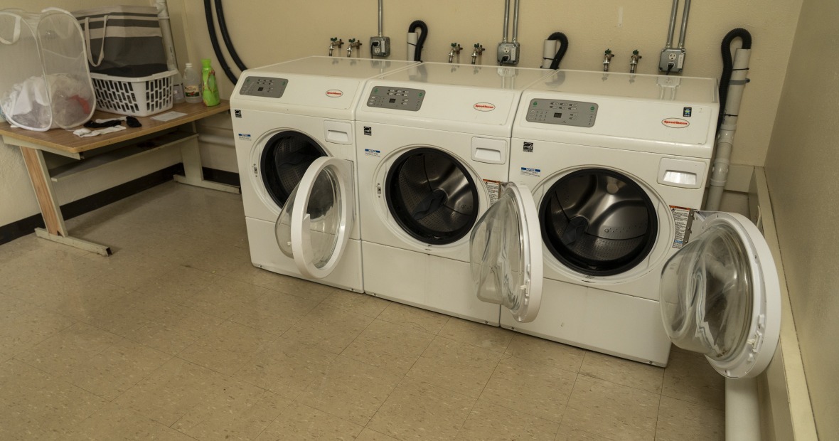 A laundry room showing washers and a table. Dryers are available but not in view.