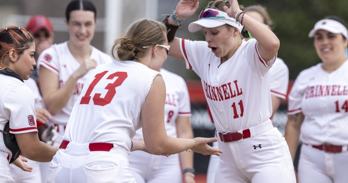 Two softball players high five while getting pumped up for the start of the game.
