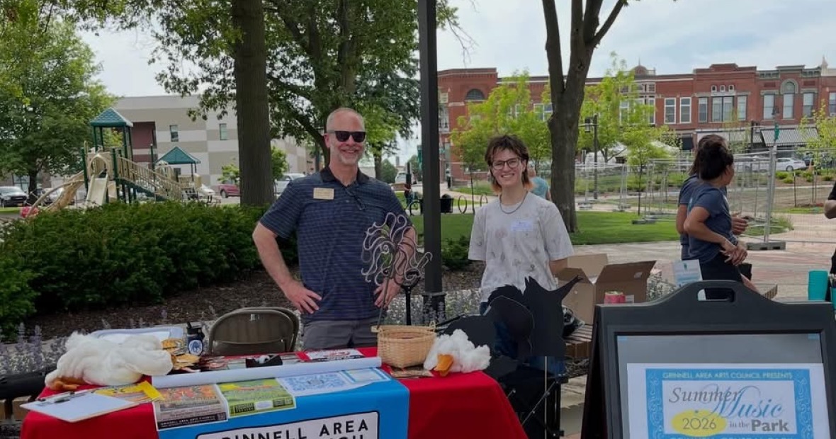 2 people standing behind a table outside 