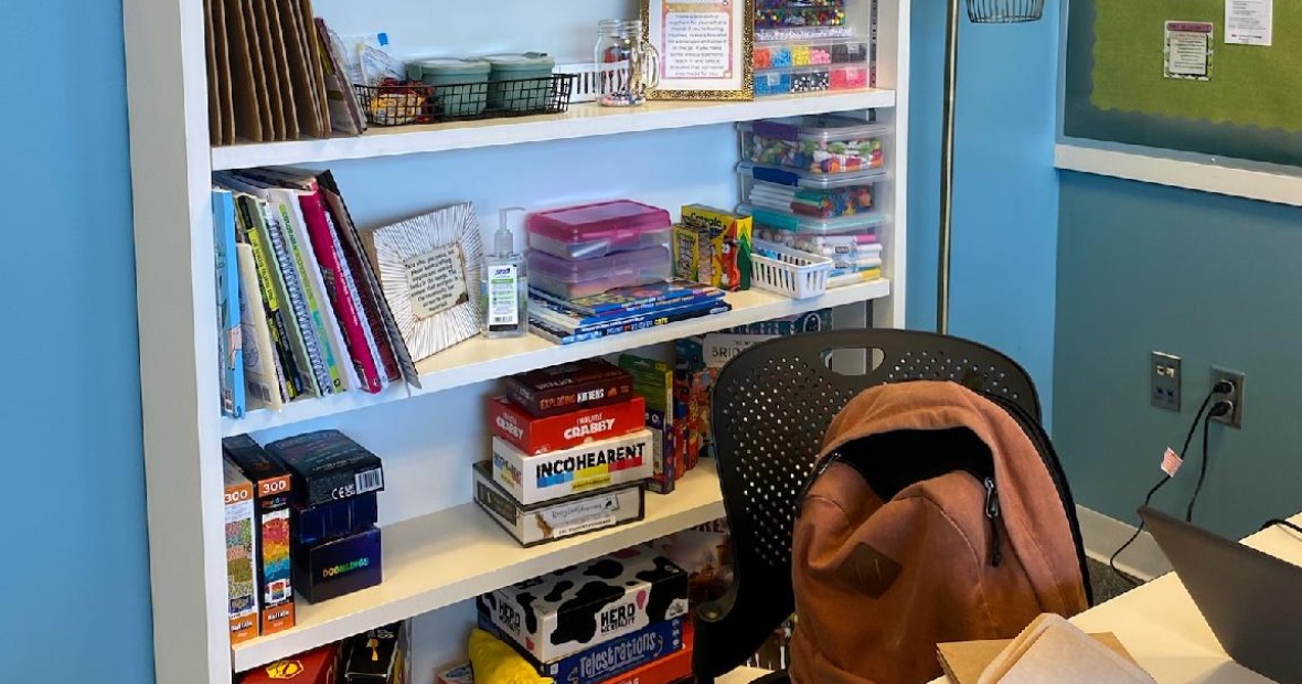 bookshelf in lounge filled with books, puzzles, games, and coloring