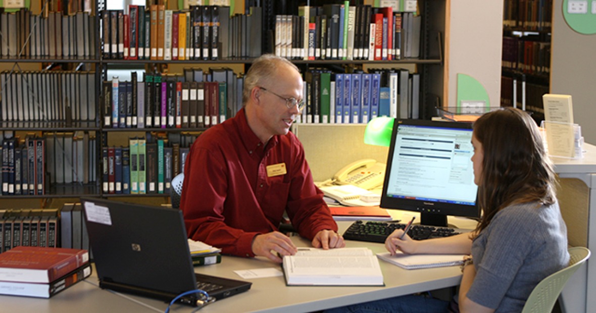 A student gets research help in the library.