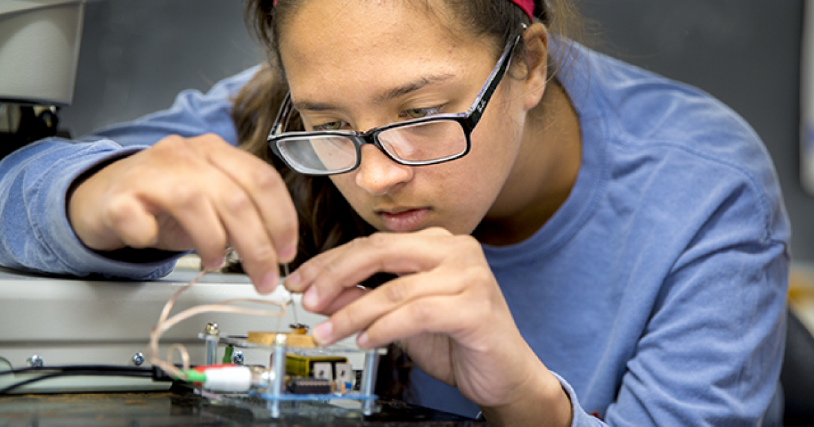 A student works with circuitry in a Grinnell Science Project lab