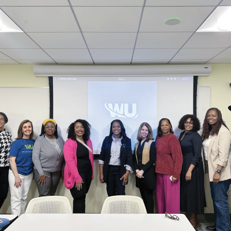 Large group of people in front of a slide of the WU logo