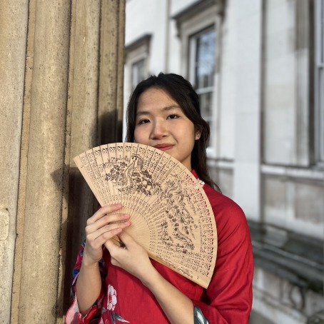 a woman in a red dress holds a fan