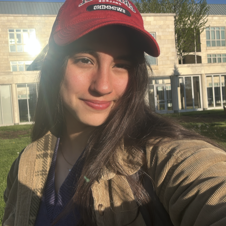 A woman with a red cap smiles for a photo
