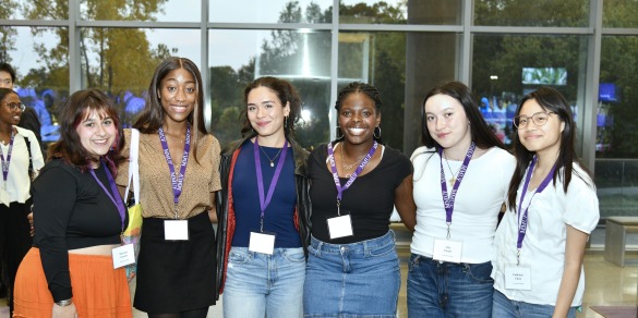Six students standing in a row with their arms around each other.