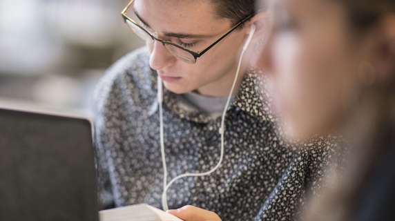 Student studying in Burling library with ear buds in
