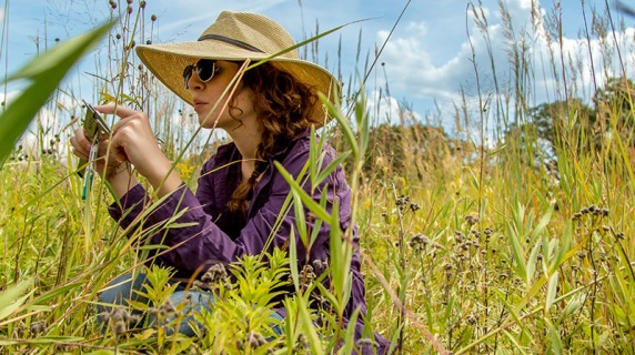 Student in sun hat takes photos of prairie life at CERA