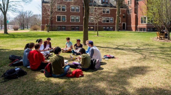 Students having class outside on the grass