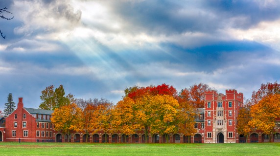 Rays of sun peek through clouds above north campus in the fall