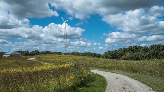 Scenic image of winding road leading to windmill and building at Conard Environmental Research Area 