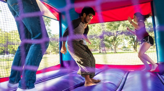 Students bouncing in a bounce house on campus