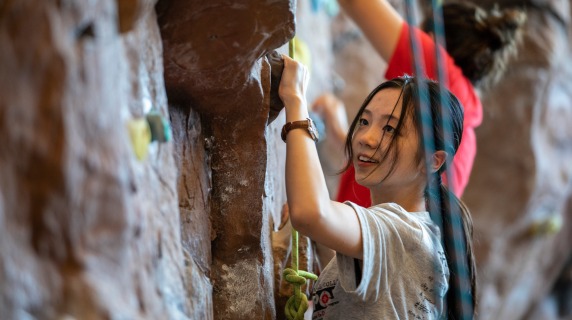 Student scaling the climbing wall in Bear Athletic and Recreation Center