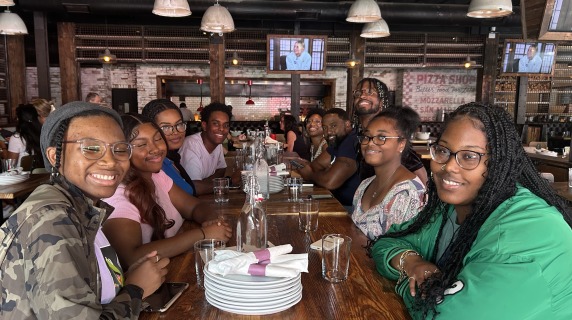 A cohort of Laurel Scholars sits at a restaurant table
