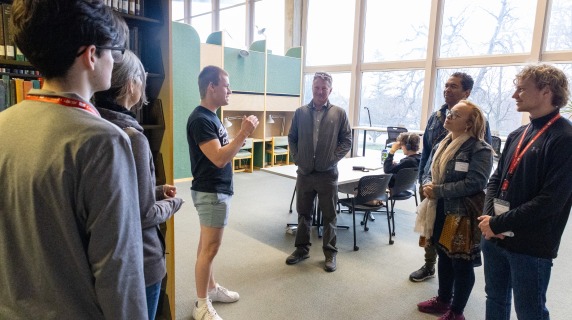 a tour group stands inside a library