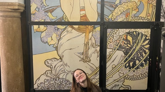 Aubrie Connell sitting in front of art work.