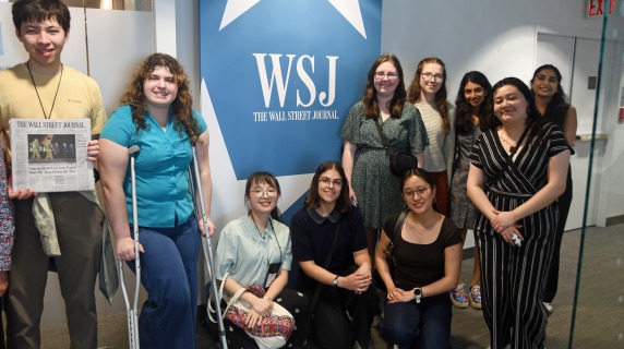 students near a wall street journal sign