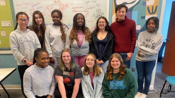 11 student leaders huddle together in the FGLI lounge and smile for a photo