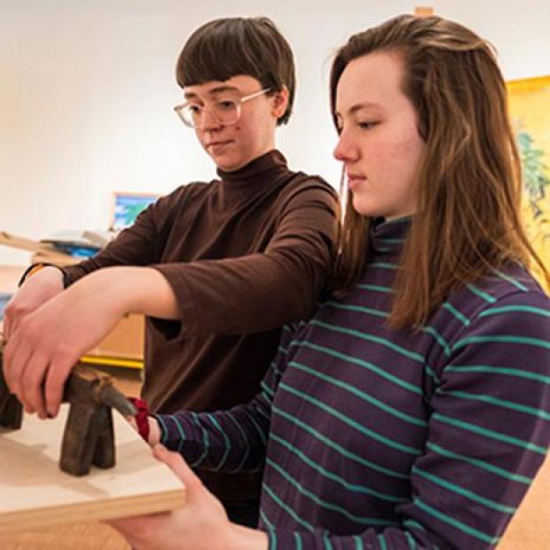 Students place small sculpture in exhibit