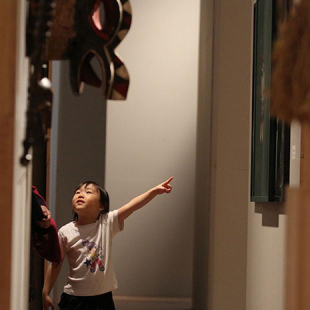 child points at painting in gallery