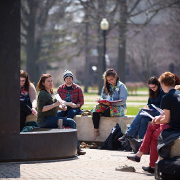 A class taking in some fresh air and meeting by the sundial outside of Noyce.
