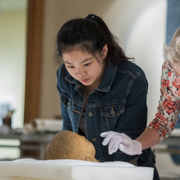 Monessa Cummins, associate professor of classics, and Jiayun Chen ’19, a classics and art history double major, examine a marble Roman portrait head, believed to be from the 1st century, in the print study room of the Burling Library.