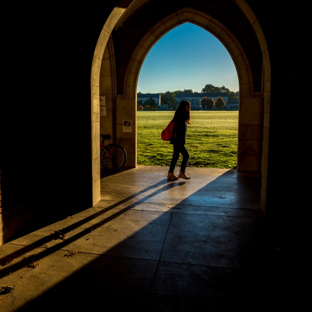 Student passing arches in Gates Rawson Tower