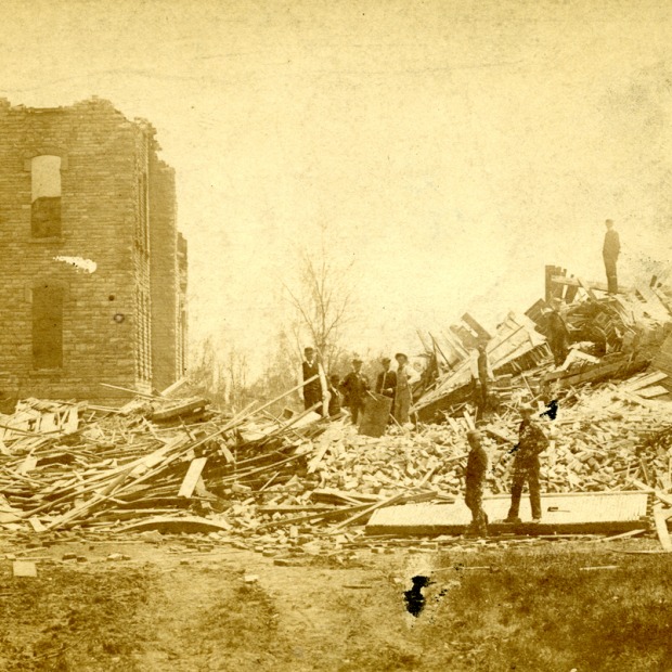 Two men survey destroyed buildings