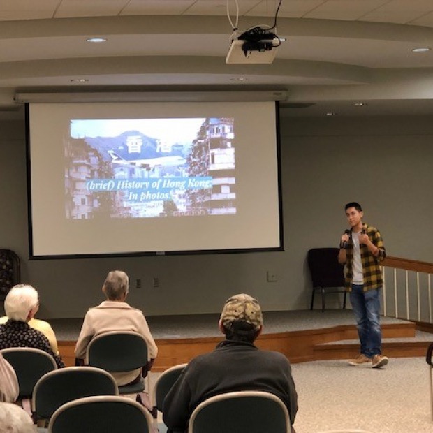Calvin Tang speaking to an audience at the Mayflower Community