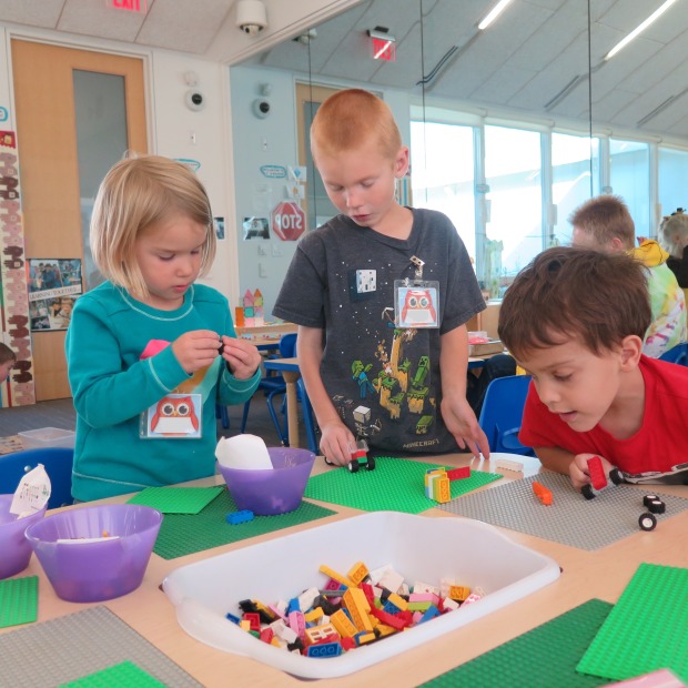 Three preschool students working at the lego table