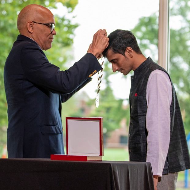 President Kington places a medal over the head of Shafiq R. Khan