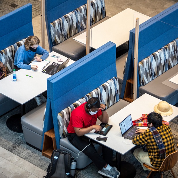 3 students studying in the HSSC atrium