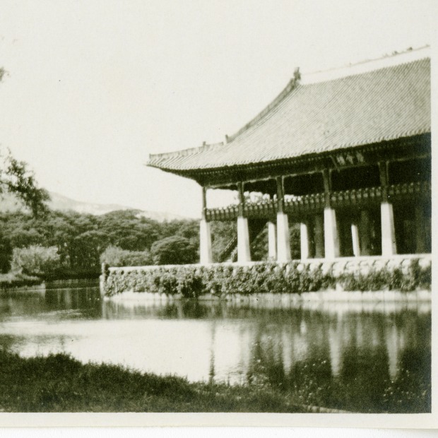 Black and white photo of a possible temple in China, next to a pond