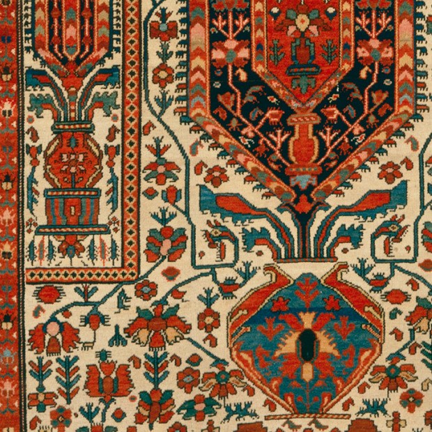 Close up view of a rug composed of red, green and gold.