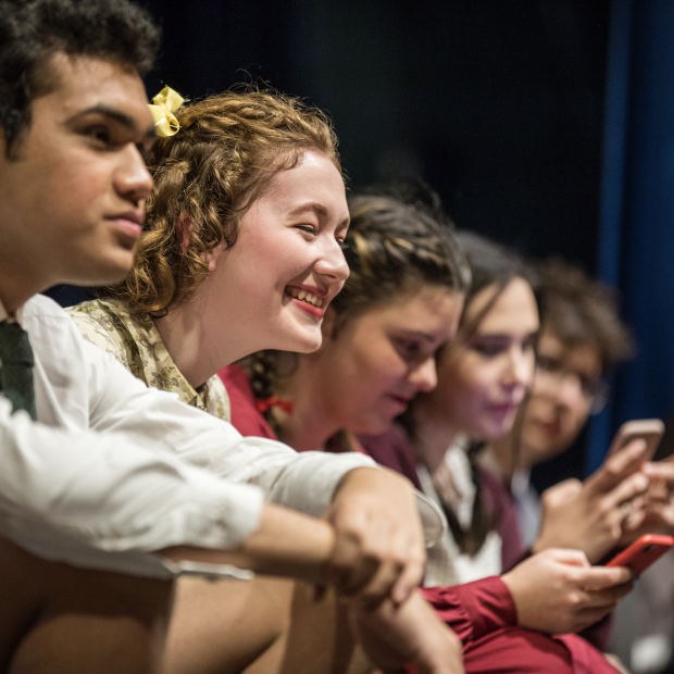 Students smile on theater stage