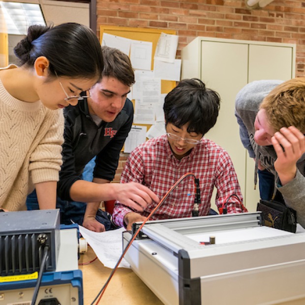 4 students conduct physics lab
