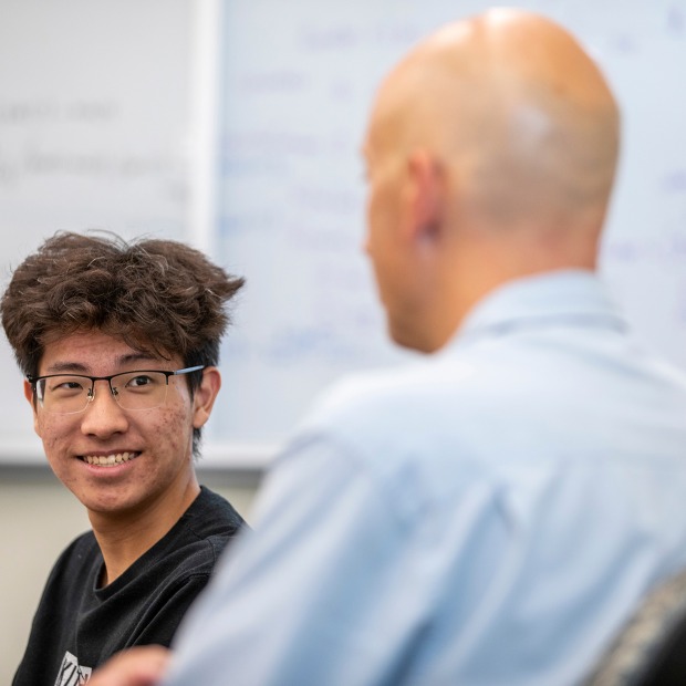 A smiling student talks with an alumni mentor