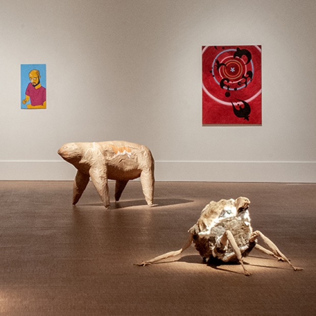 Installation view of BAX 2023 showing a portrait of a student, an abstract painting, and two animal sculptures on the floor