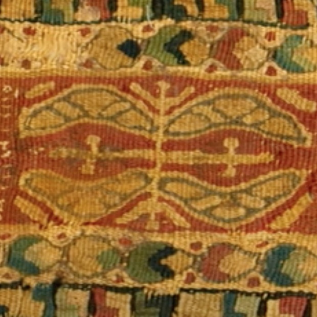 Detail of a Coptic textile fragment in shades of red, gold, green, and black