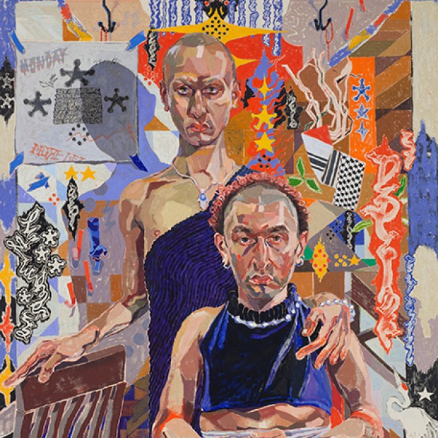 Frontal portrait of two siblings, one standing and one seated, against a wall of brightly colored graffiti like symbols. 